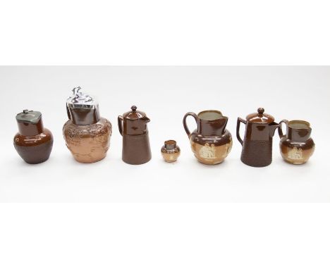 A collection of late 19th Century stone ware jugs, one of which has a silver top with hunting scenes portrayed, along with Do