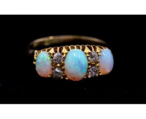 An opal and diamond 18ct gold ring, comprising three graduated oval opals, with double diamond set accents, width approx 8mm,