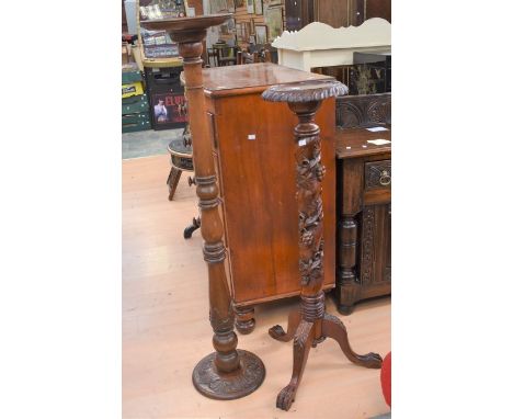 Two 20th Century mahogany torcheres, one carved with grape vine details, with tripod bird feet legs
