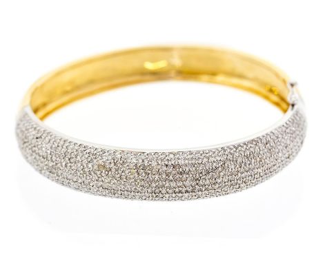A diamond and 18ct gold hinged bangle, the domed white gold front pave set with brilliant cut diamonds, width approx.11mm, in