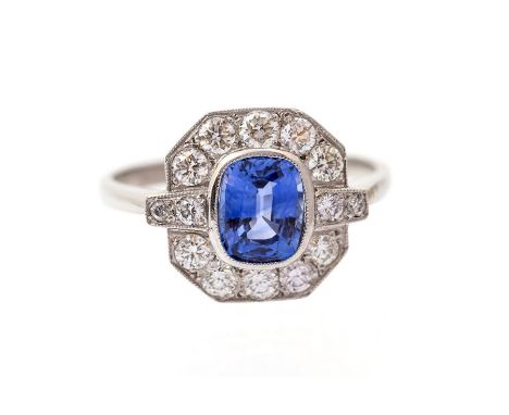 An Art Deco style sapphire and diamond ring, comprising a central rub over set cushion cut sapphire, weighing approx. 1.55car