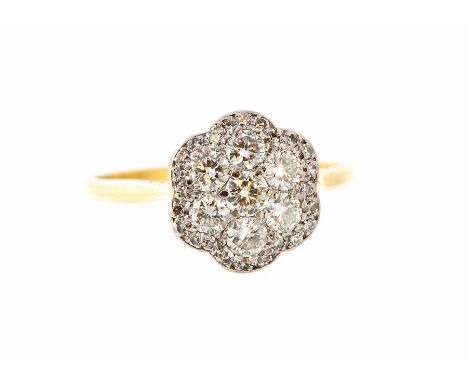 A diamond flowerhead cluster ring, seven principal round brilliant-cut diamonds with border surround of small round eight-cut