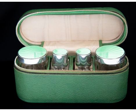 An Art Deco silver and guilloche enamel travelling toilet set including a pair of cologne/perfume bottles and a pair of circu