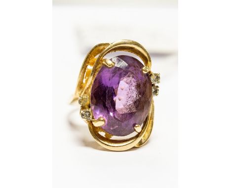 An amethyst and diamond set dress ring, comprising a claw set oval cut amethyst, size approx. 15mm x 20mm, with four small br