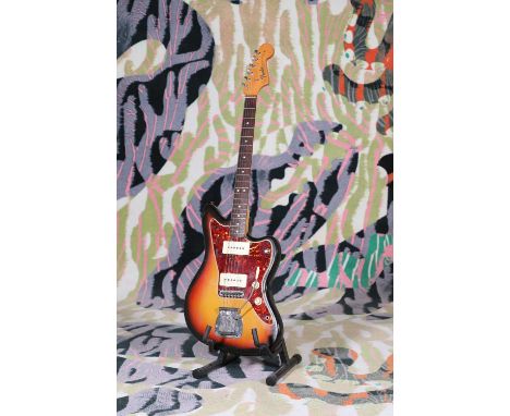 A 1965 Fender Jazzmaster electric guitar, serial number 'L7***9', of typical form in a three-tone sunburst finish with a tort