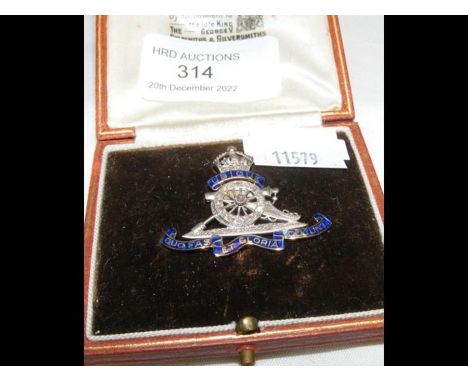 A boxed two tone gold, enamel and diamond artillery brooch