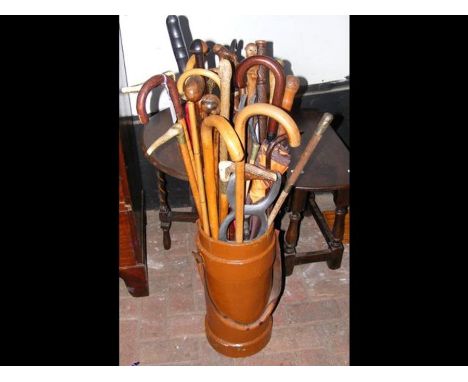 A leather umbrella/stick stand containing various walking sticks, swagger stick