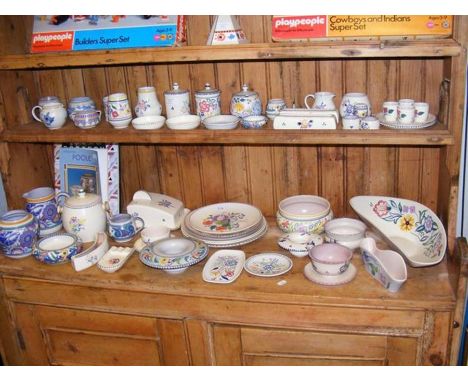 A generous quantity of Poole Pottery having floral patterns - on two shelves  