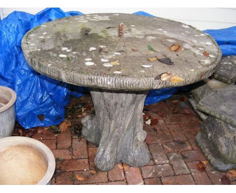 An unusual concrete faux tree trunk garden table