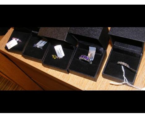 An amethyst five stone ring in silver setting together with four others
