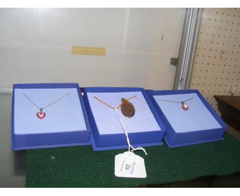 A 9ct gold ruby and diamond heart pendant on gold chain together with two others