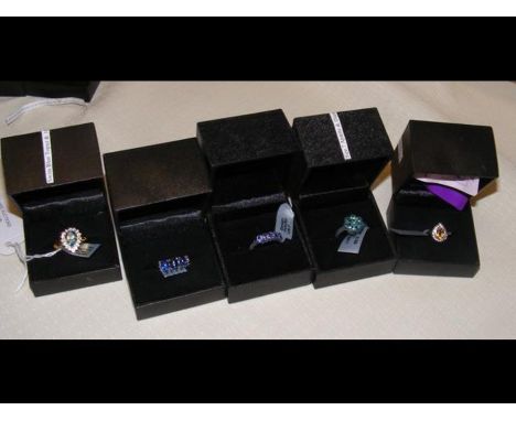 A garnet and white topaz ring with certificate together with four others