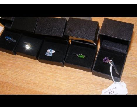 A Swiss blue topaz ring in silver setting together with four others