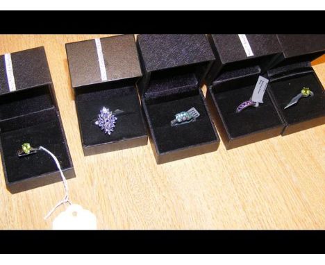 A peridot ring in silver setting together with four others