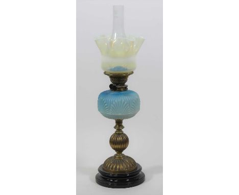 A 19th century brass oil lamp, having a vaseline glass shade and blue silk glass font, h.67cmLarge chip to pottery base.Trail