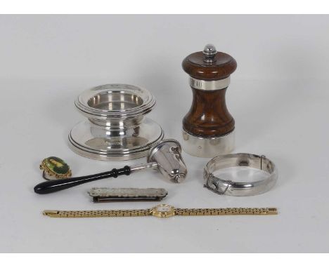 A collection of various items to include a silver candle snuffer, silver pepper grinder, Victorian mother-of-pearl buckle, et