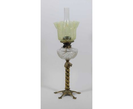 A 19th century brass oil lamp, having a vaseline glass shade upon a clear glass font, and spiral brass stem, h.71cmThe shade 