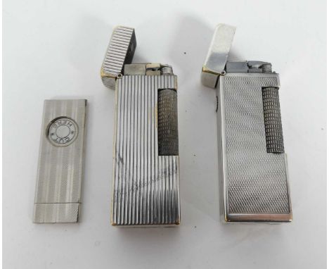 A Dunhill pocket cigarette lighter, together with another similar Dunhill pocket cigarette lighter and a pocket cigar cutter 