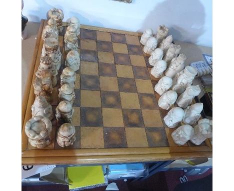 A large chessboard, bamboo border on a pine board with leather squares, 69 x 69cm, together with ceramic chess pieces, (qty) 