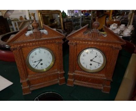 Two oak mantel clocks, broken swan neck pediments with turned finial above Ionic columns, Arabic enamel dials, drum movements