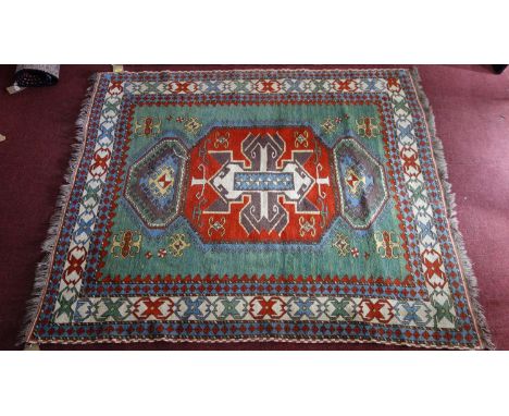 A Kazak carpet, geometric medallion on a turquoise ground, contained by geometric borders, fringed, 87 x 163cm 