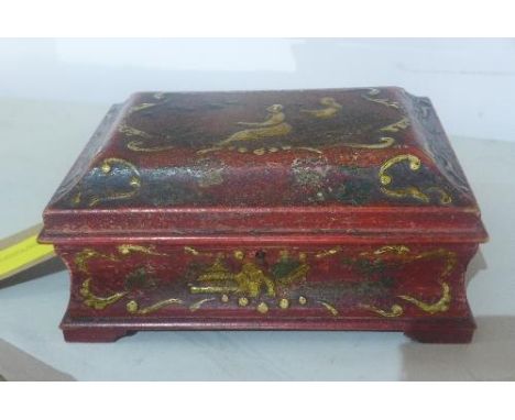 A red lacquered box, of casket form, decorated in the Chinoiserie taste with figures and scrolling foliage, raised on bracket