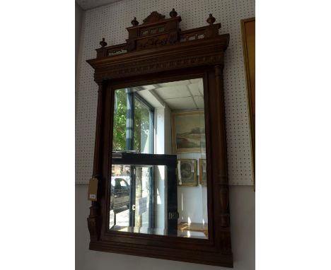 An early 20th century French oak overmantle mirror, with carved crest, reeded pillar supports, having bevelled plate, 138 x 8