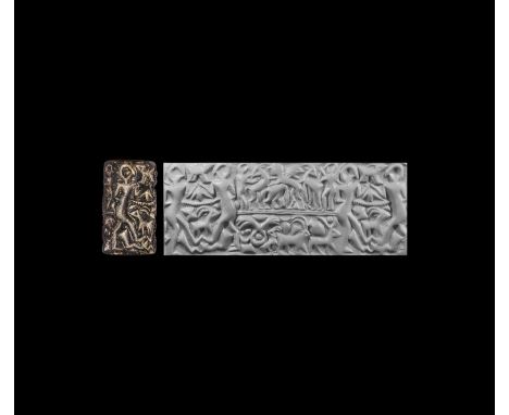 2nd millennium BC. A large serpentine cylinder seal with two full-height figures engaged in combat separating two registers o