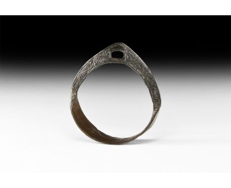 8th-10th century AD. A ferrous stirrup with ribbed footplate, arched body, curved bracket with slot to accept the strap, rese