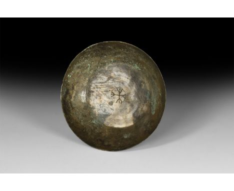 5th-7th century AD. A shallow bronze bowl with faintly incised concentric circles on the inner base and a cross engraved in t