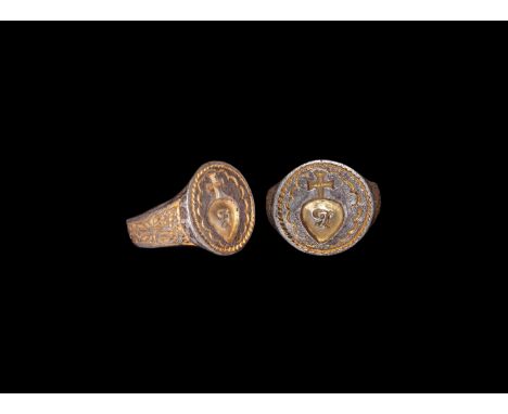16th-17th century AD. A silver-gilt finger ring comprising a tapering flat hoop with foliage detailing to the flanks, discoid
