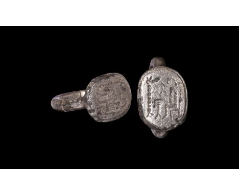 6th-4th century BC. A silver finger ring comprising a substantial round-section hoop, discoid bezel with intaglio seated figu