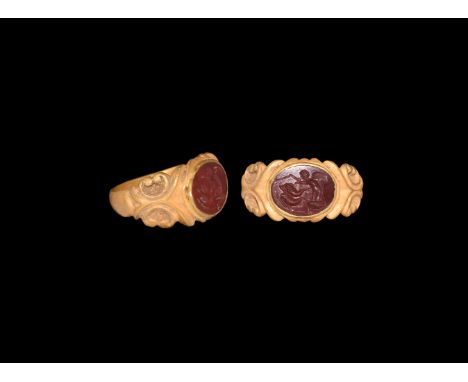 2nd-3rd century AD. A jasper intaglio with putto and two dolphins; set into a later gold finger ring comprising a flat-sectio