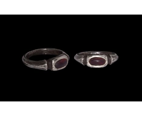 Late 16th century AD. A silver finger ring with keeled hoop, segmented bezel, inset garnet cabochon.   8.34 grams, 26.44mm ov