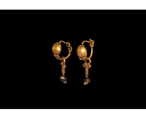 2nd century AD. A matched pair of gold earrings each a hemispherical dome with filigree volute scroll, hook-and-eye catch, da