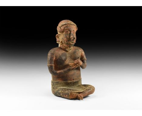 3rd century BC-5th century AD. A large seated Nayarit culture male warrior figure, wearing a wrapped skirt with legs folded a