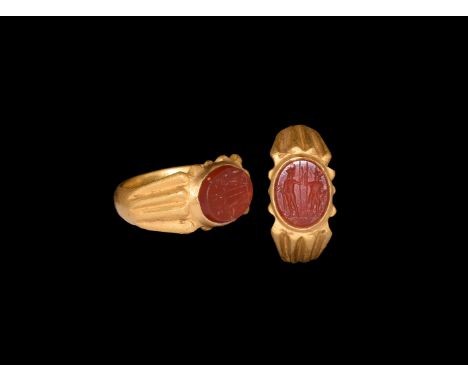 2nd century AD. A carnelian cloison intaglio of two standing figures with spears; set into a later substantial gold finger ri