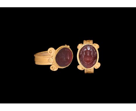 2nd-3rd century AD. A cloison garnet intaglio with vase, flowers and seeds; set into a later gold finger ring comprising a br