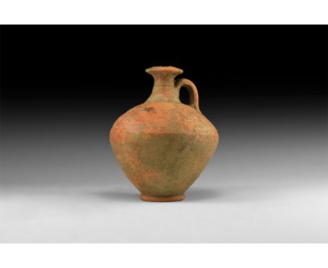 1st century AD. A terracotta flask with bulbous-shaped body, long neck with wide rim and looped handle.   294 grams, 13cm (5"