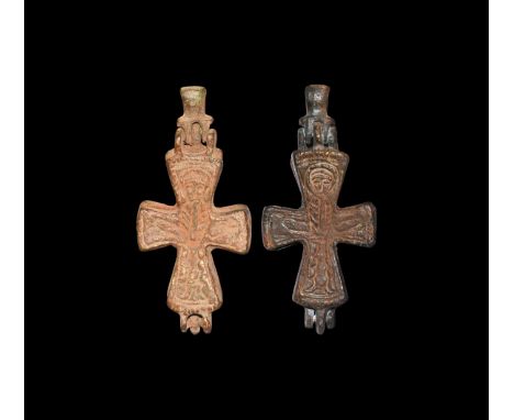 9th-10th century AD. A group of two bronze reliquary cross pendants, each with hinged loop, low-relief robed nimbate figure t