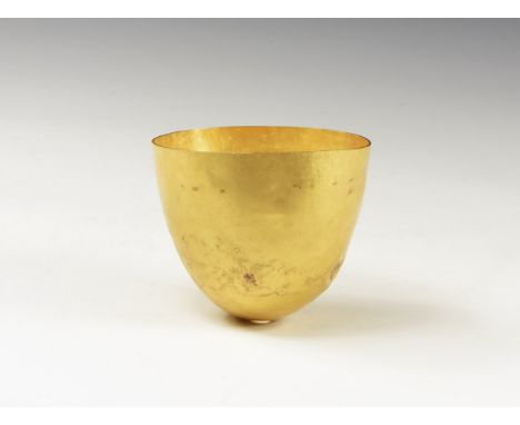 2nd-1st century BC. A gold cup formed from a single sheet of metal, with thin rim and body tapering to the rounded base; smal