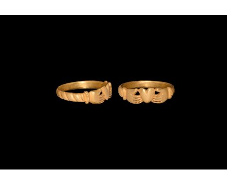 17th-18th century AD. A gold finger ring comprising a barleytwist hoop and bezel formed as two open hands supporting a heart.