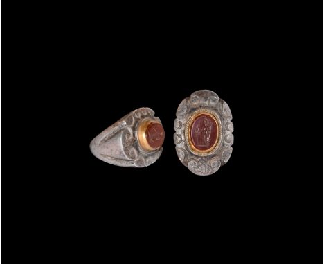 3rd century AD. A substantial silver finger ring comprising a tapering hoop and flared segmented shoulders, flat plaque with 