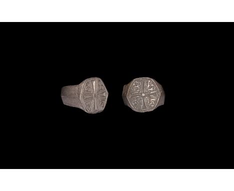15th century AD. A silver finger ring comprising a keeled hoop, hexagonal bezel with reserved voided cross amid tendrils.   9