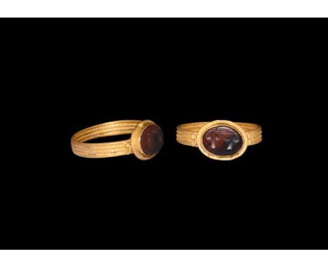 3rd century AD. A carnelian cloison intaglio with grapes or leaves motif; set into a later gold finger ring comprising a flat