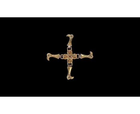 5th century AD. A silver-gilt strap distributor comprising a central gold cell with discoid garnet cloison insert, four radia