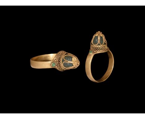 13th-15th century AD. A gold finger ring comprising a flat-section hoop with cell to each shoulder, inset emerald(?) cabochon