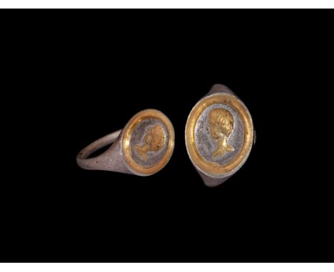 1st century AD. A silver-gilt finger ring with round-section tapering hoop, elliptical bezel with recessed border and intagli