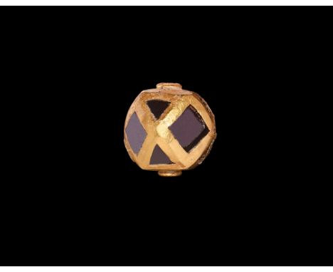 6th century AD. A hollow-formed gold polyhedral bead with lozengiform and triangular inset cloisons, pierced on two faces to 