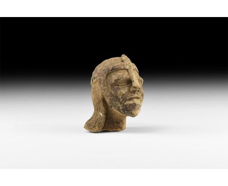 14th-15th century AD. A ceramic head wearing a helmet with ear-guards, nasal and segmented ventail.   837 grams, 12cm (4 3/4"